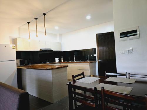 a kitchen with a table and a kitchen with a refrigerator at Holiday 休闲公寓 in Nakavu