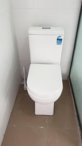 a bathroom with a white toilet in a room at Holiday 休闲公寓 in Nakavu
