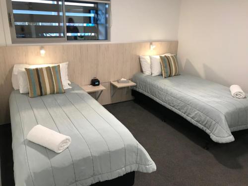 a hotel room with two beds and a window at Beachfront Hotel Hokitika in Hokitika