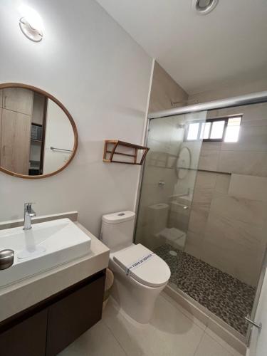 ein Badezimmer mit Toilette, Waschbecken und Spiegel in der Unterkunft LOFT NUEVO ! En Cerritos OCEANNA frente al MAR ! - 237 B - in Mazatlán