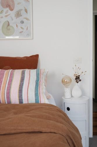 a bedroom with a bed and a white night stand at The Dreaming in Saint Andrews Beach