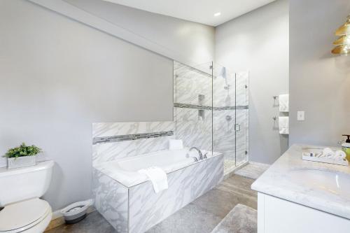 a white bathroom with a tub and a toilet at Lakeview Townhome Unit A5 in Avon