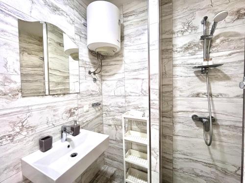 a bathroom with a sink and a shower at Apartments Sunset in Mlini