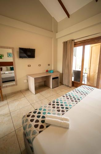 a bedroom with a bed and a desk with a television at Colina de Montalva in Tarapoto