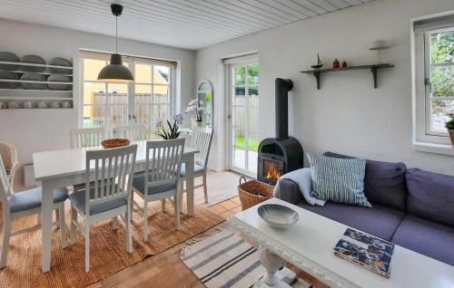 a living room with a couch and a table and a fireplace at Amazing Home In Skagen With Wifi in Skagen
