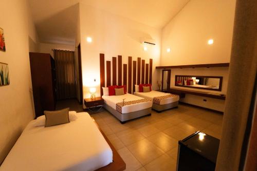 a hotel room with two beds and a mirror at Colina de Montalva in Tarapoto
