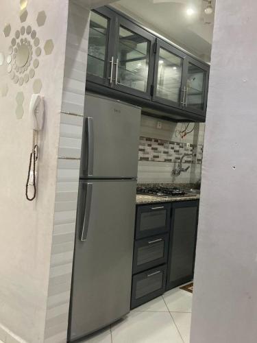 a kitchen with a stainless steel refrigerator and cabinets at طريق الخير 13 in Agadir