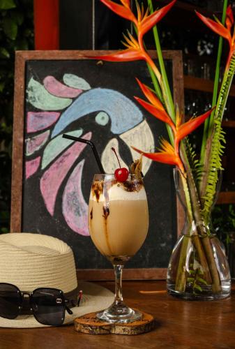 a drink in a glass on a table with a hat at Colina de Montalva in Tarapoto