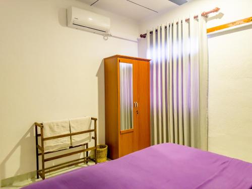 a bedroom with a bed and a wooden door at Bungalow By Tropical Villa in Weligama