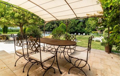 - une table et des chaises sous un parasol sur la terrasse dans l'établissement Cozy Home In Pernes Les Fontaines, à Pernes-les-Fontaines