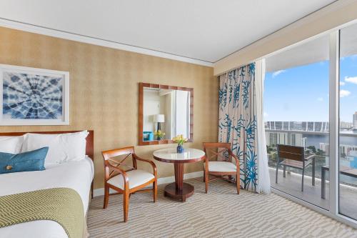 a hotel room with a bed and a table and a window at Lujoso apartamento en playa de Sunny Isles Beach in Sunny Isles Beach