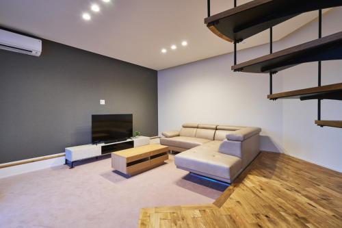 唐津市にある水響邸-blue sound villa-のソファと薄型テレビのあるリビングルーム