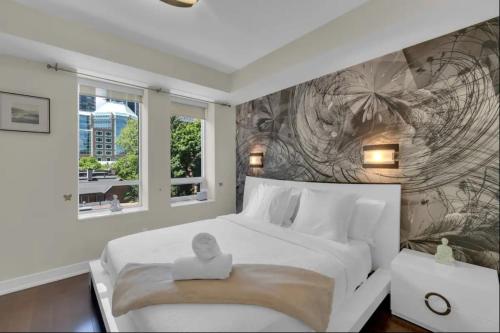 a bedroom with a large white bed with a picture on it at 1560 sqft Elegant Condo at Downtown Hi-End Shopping & Dining Area - CN Tower View, Bidet, LockBox in Toronto