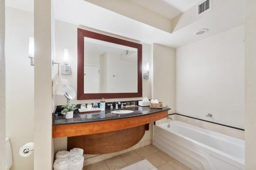 a bathroom with a sink and a tub and a mirror at Lujoso apartamento en playa de Sunny Isles Beach in Sunny Isles Beach
