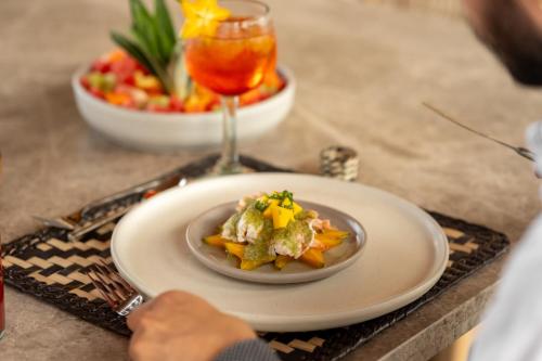 a plate of food on a table with a drink at ONTO House Puerto Escondido in Tlachicón