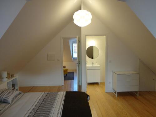 a attic bedroom with a bed and a light at Casa Aveiro Canal da Ria in Aveiro