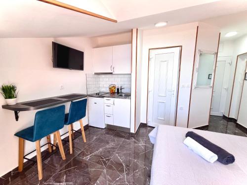a kitchen with a table and chairs in a room at Apartments Sunset in Mlini