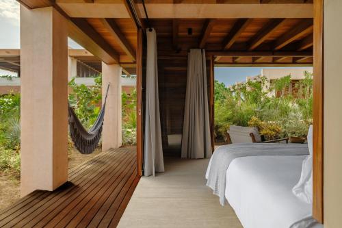 a bedroom with a bed on a wooden deck at ONTO House Puerto Escondido in Tlachicón