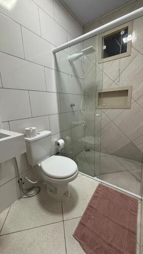 a bathroom with a toilet and a glass shower at espaço R&H in Macapá