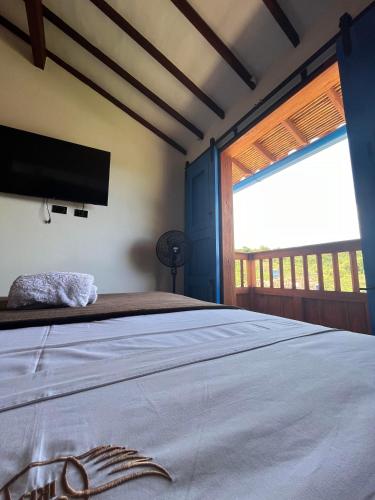 a bedroom with a bed with a flat screen tv at Casa Iris Hotel Boutique in Barichara