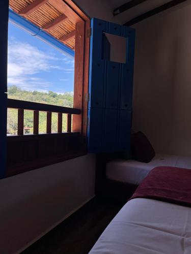 a bedroom with a window with a bed and a balcony at Casa Iris Hotel Boutique in Barichara