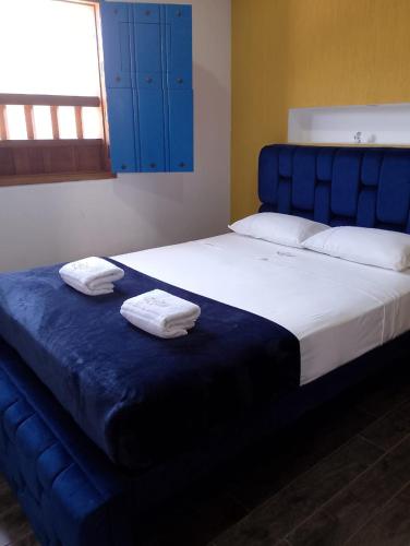 a large bed with two towels on top of it at Casa Iris Hotel Boutique in Barichara