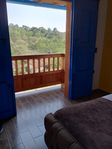 a bedroom with a balcony with a large window at Casa Iris Hotel Boutique in Barichara