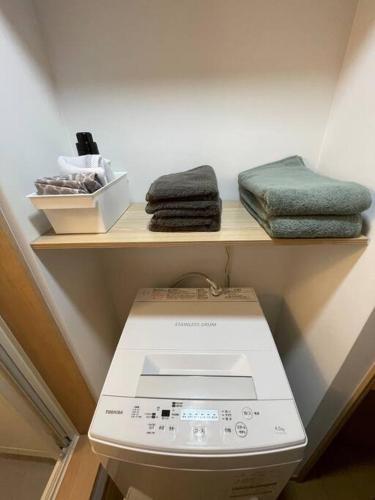a shelf above a toilet with towels on it at RestGarden405 レストガーデン405 in Kagoshima