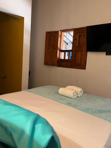 a bedroom with a bed with a window and a towel at Casa Iris Hotel Boutique in Barichara
