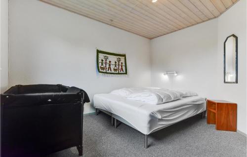 a white bedroom with a bed and a chair at Gorgeous Home In Løgumkloster With Wifi in Agerskov