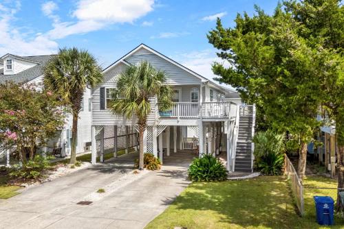 una casa con delle palme davanti di Beach House with Pool - North Myrtle Beach a Myrtle Beach