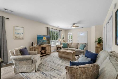un soggiorno con divano, sedie e TV di Beach House with Pool - North Myrtle Beach a Myrtle Beach
