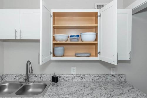 a kitchen counter with white cabinets with bowls in it at Buckhead 2br Free Parking & Wi-fi in Atlanta