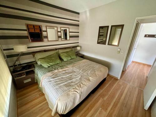 a bedroom with a bed with green pillows at Hermoso departamento en Vicente Lopez in Florida