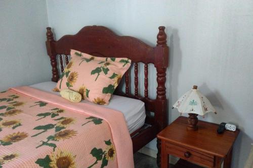 a bed with a pillow and a table with a lamp at Hostel Residence Girassol in Belém