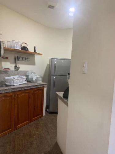 a kitchen with a stainless steel refrigerator and wooden cabinets at Suite Bosques de Olon in Olón