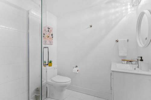 ナイアガラ・フォールズにあるVibrant 2BR Gateway with Free Parking & 7 Mins to the Fallsのトイレとシャワー付きの白いバスルーム