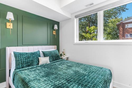 ナイアガラ・フォールズにあるVibrant 2BR Gateway with Free Parking & 7 Mins to the Fallsの緑と白のベッドルーム(ベッド1台、窓2つ付)