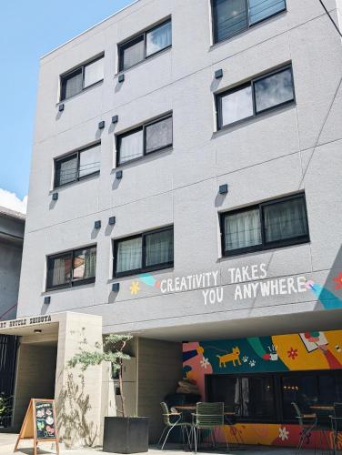 a building with a sign that reads creativity takes you anywhere at ART HOTELS SHIBUYA in Tokyo