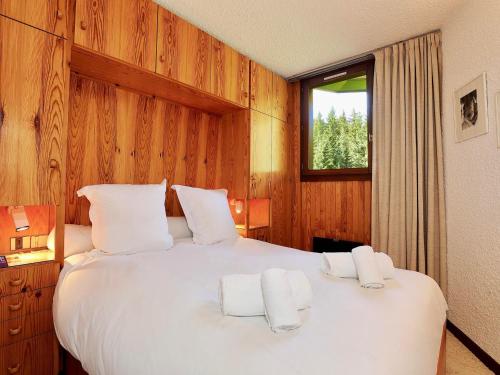 une chambre avec un grand lit blanc avec deux serviettes dans l'établissement Courchevel 1850 - Appart 4 pers avec parking et wifi - skis aux pieds - FR-1-575-216, à Courchevel
