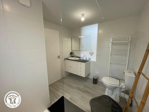 une salle de bain blanche avec des toilettes et un lavabo dans l'établissement Gîte au Marais Breton: Confort, Proximité Plages, Idéal Familles et Amis - FR-1-426-548, à Saint-Gervais