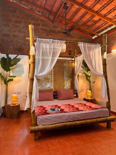 a bedroom with a bed with a canopy at Surangi Homestays in Ajgaon
