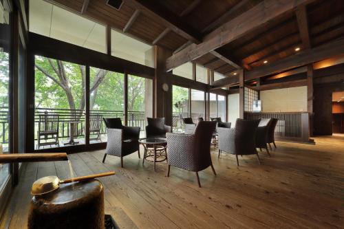 a large room with chairs and tables and windows at Zao Kokusai Hotel in Zao Onsen