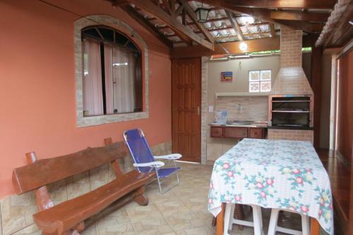 a kitchen with a table and a bench in a room at Casa da Fran in Maresias