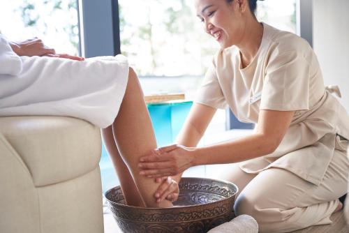a woman sitting on the floor with her leg in a bowl at Centara Grand Hotel Osaka in Osaka
