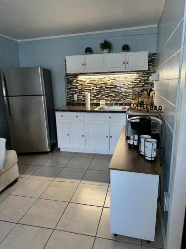 a kitchen with white cabinets and a stainless steel refrigerator at Florida Paradise in Lakeland