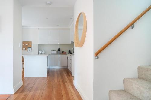 a kitchen and staircase in a house with white walls at The Newtowner - In the Heart of Newtown! in Sydney