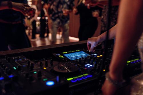 a person standing at a mixing console in a nightclub at Centara Grand Hotel Osaka in Osaka