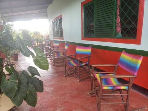 a row of chairs with rainbowcolored chairs in a room at Finca El Mirador - Agroturismo in Rivera