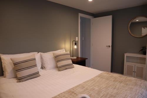 a bedroom with a large white bed with pillows at Modern Mountain Views Sunny in Kaikoura